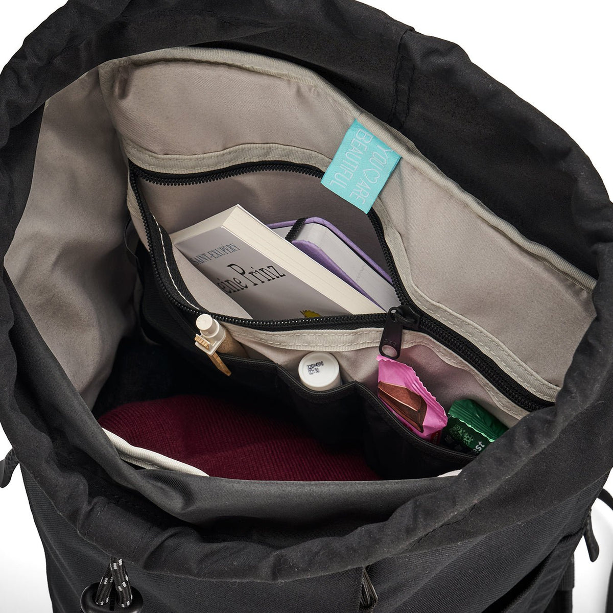 Ela Mo™ Everywhere Daypack | Embroidery Edition Upsy Daisy. Innenbereich des Rucksacks mit Fächern und Alltagsgegenständen.