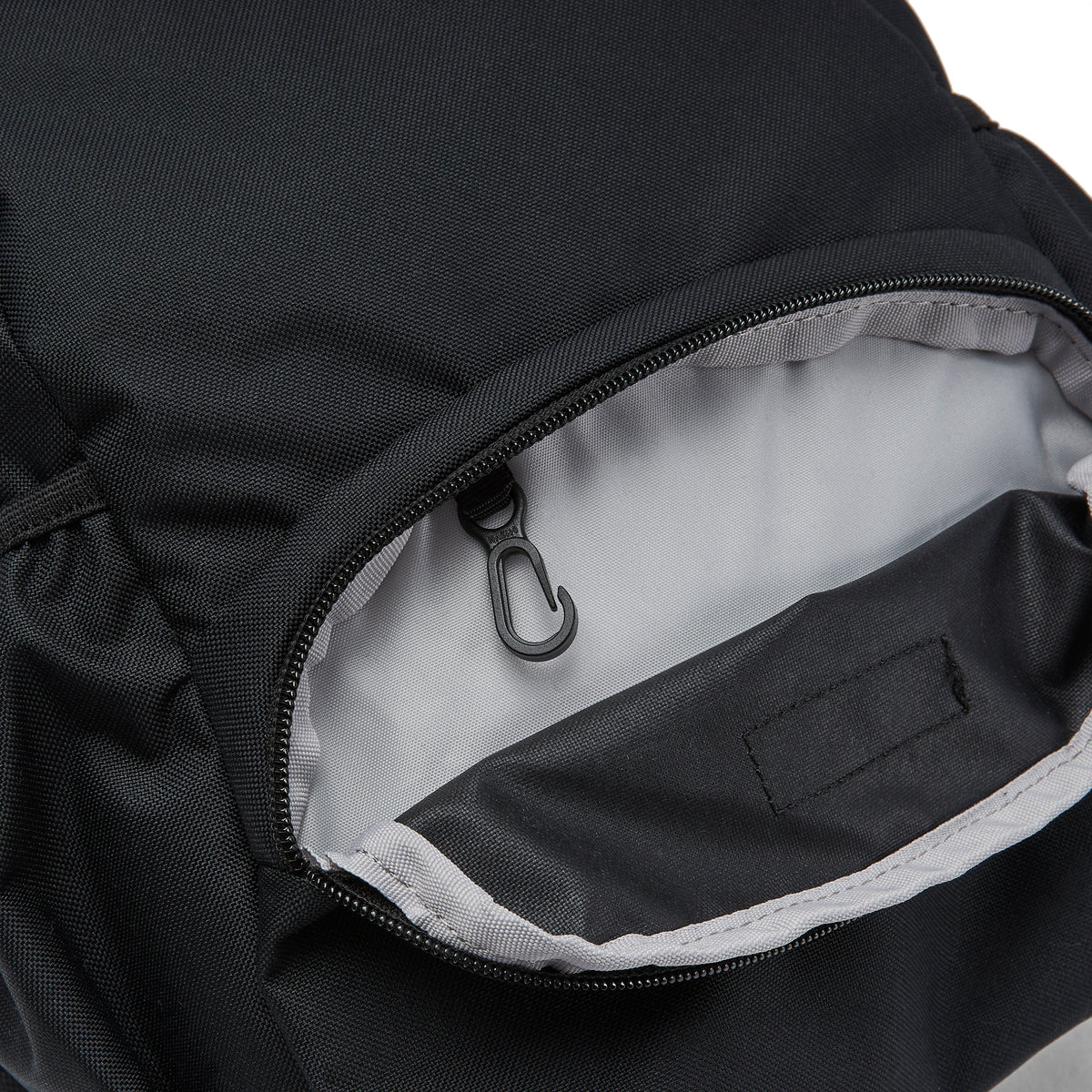 Ela Mo™ Mini Rucksack | Schwarz. Innenbereich des Außenfachs mit integriertem Schlüsselanhänger.
