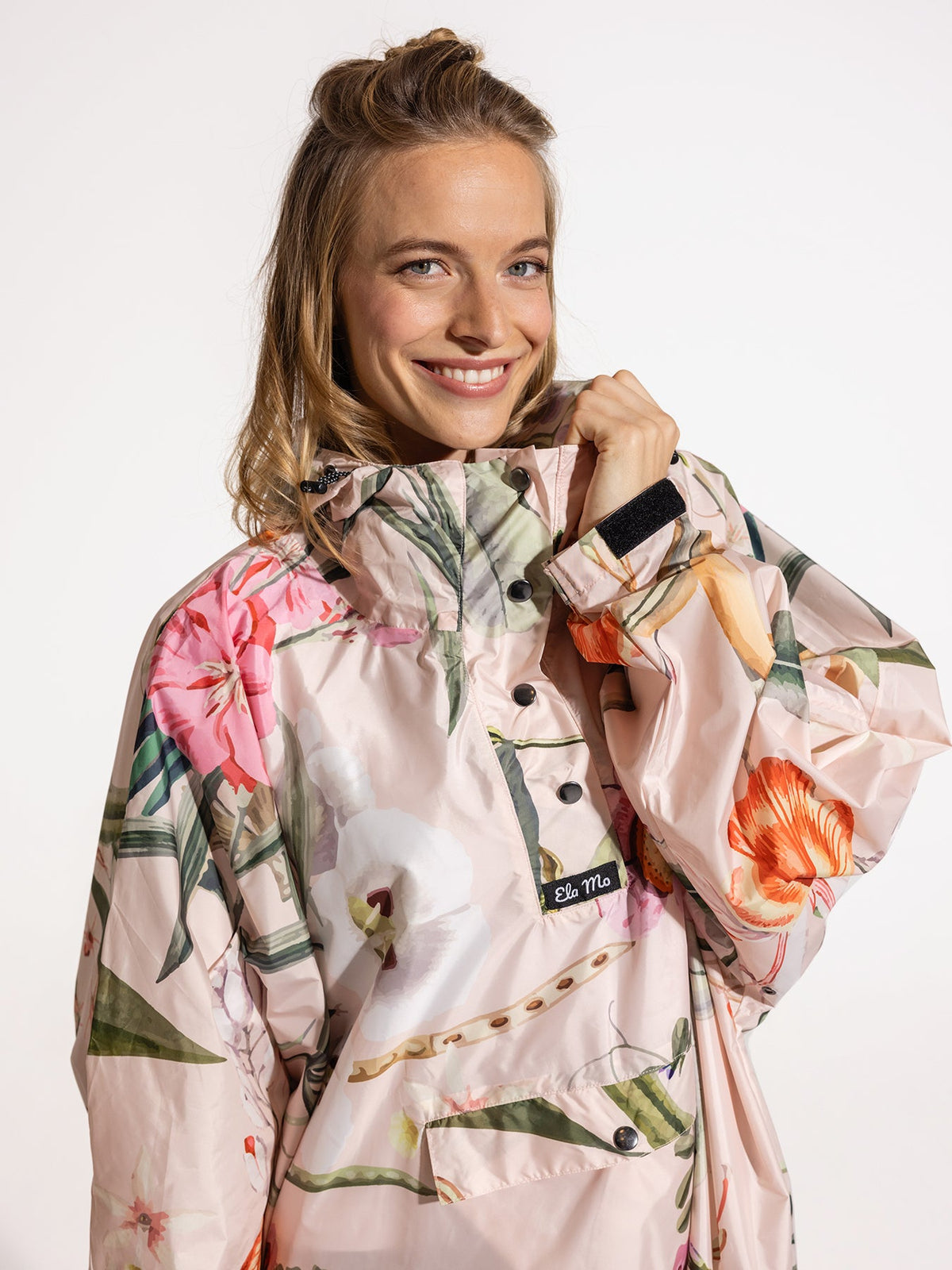 Ela Mo™ Regenponcho | Luxe. Eine Frau im Regenponcho mit hohem Kragen.