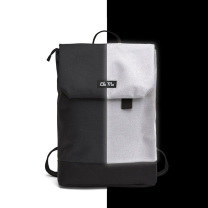 Ela Mo™ Daypack Rucksack | Black Reflective. Ein schwarzer, reflektierender Rucksack mit Herstellerlogo vorne.