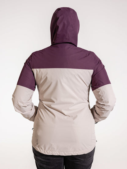 Ela Mo™ Regenjacke | Grape. Eine Frau von hinten in einer Regenjacke mit Reißverschluss und aufgesetzter Kapuze.