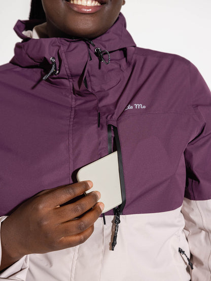 Ela Mo™ Regenjacke | Grape. Frau in  Regenjacke mit einer seitlichen Handytasche, die durch Reißverschluss geschützt ist.