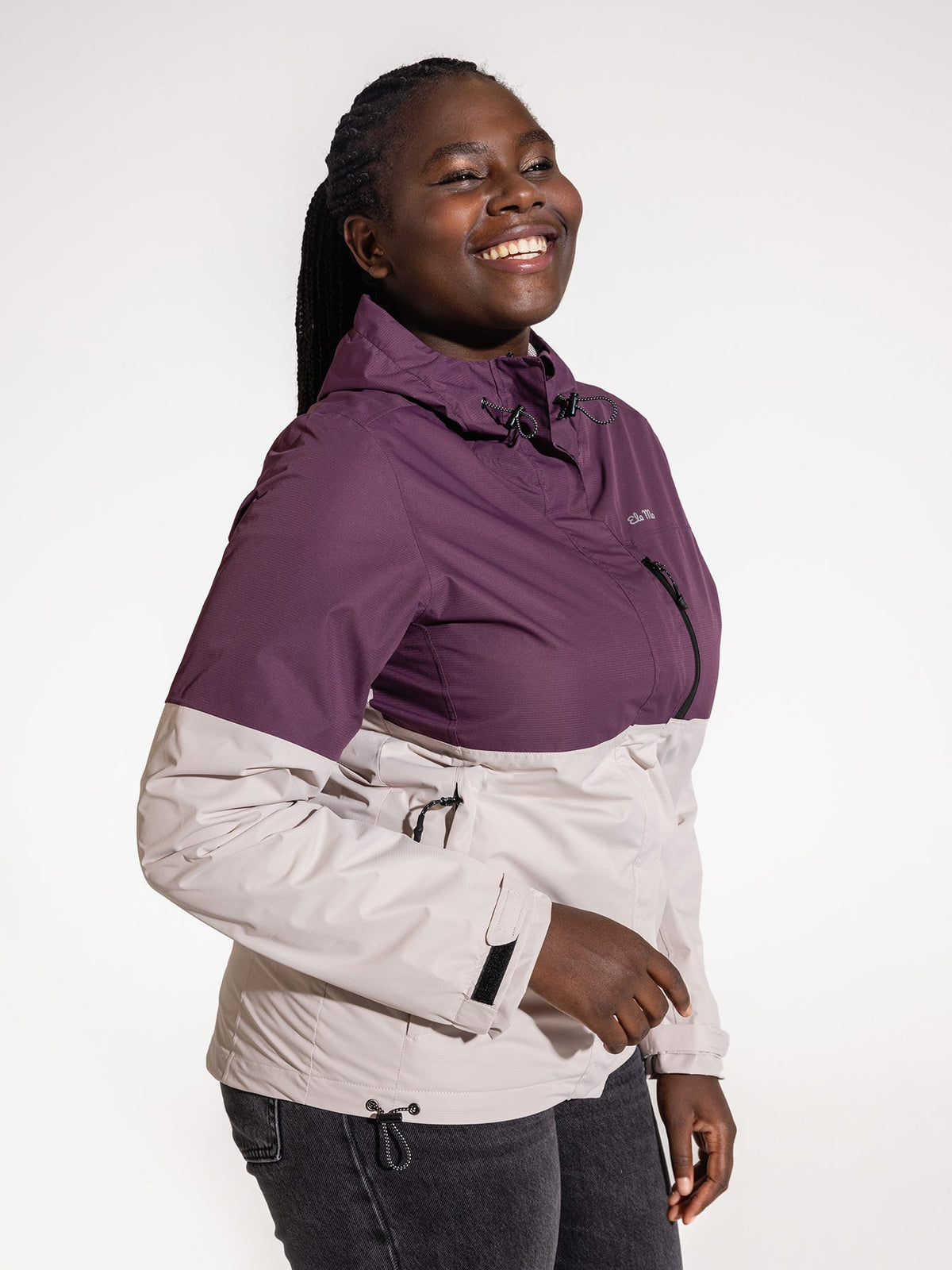Ela Mo™ Regenjacke | Grape. Eine Frau in einer bequemen Regenjacke mit Reißverschluss vor weißem Hintergrund.