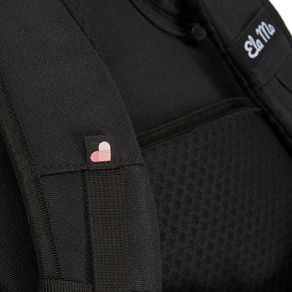 Ela Mo™ Everywhere Daypack | Black. Schulterriemen des schwarzen Rucksacks mit kleinen Herzchen und Herstellerlogo darauf.