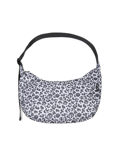 Ela Mo™ Moon Bag | Leo. Umhängetasche im Leopardenmuster mit schwarzem, verstellbarem Schulterriemen und Herstellerlogo.