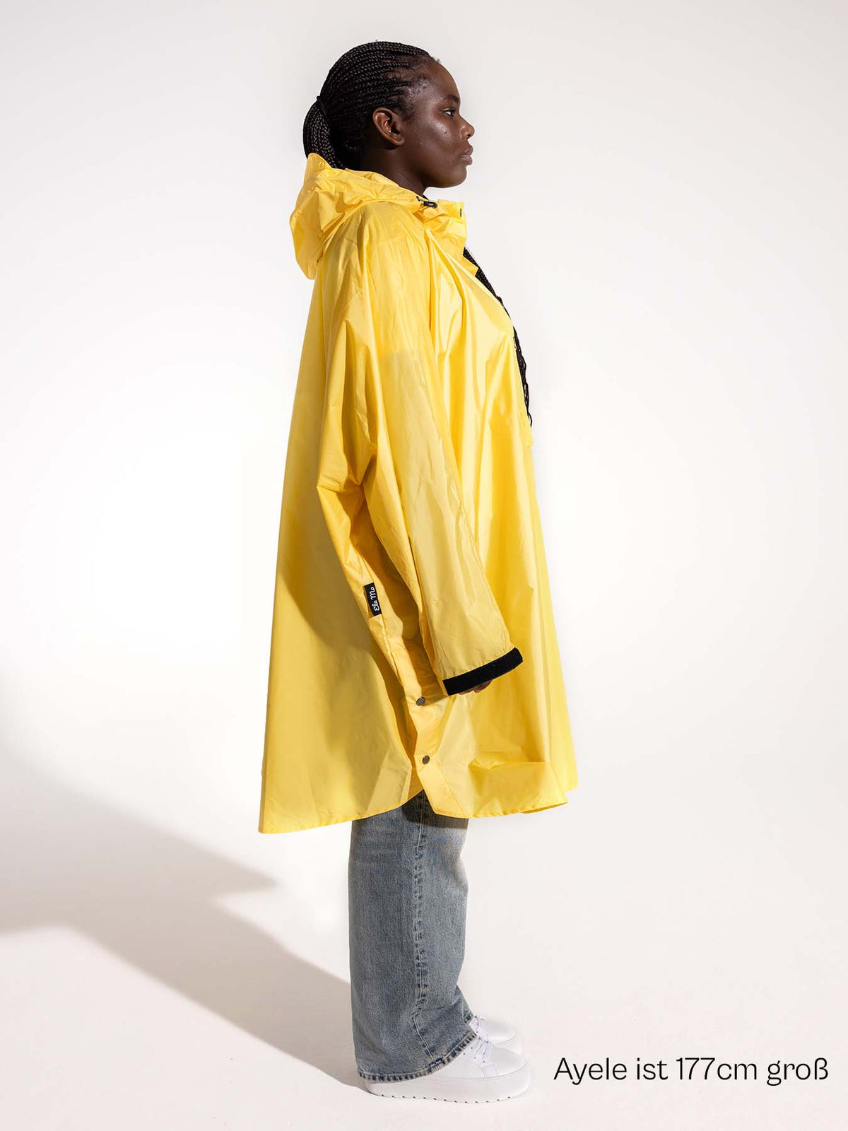 Ela Mo™ Regenponcho | Yellow. Eine Frau im Regenponcho, mit Angabe ihrer Körpergröße.