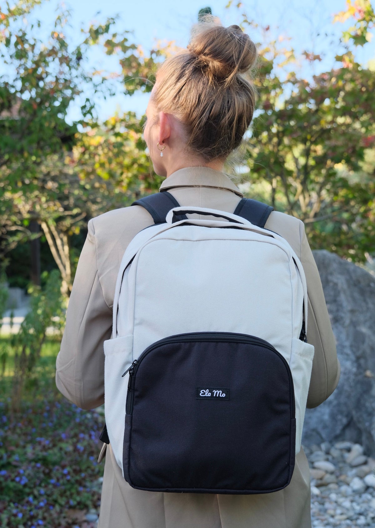 Ela Mo™ Work Rucksack | Desert. Ein Mädchen mit dem grauen Schulrucksack auf der Straße.“